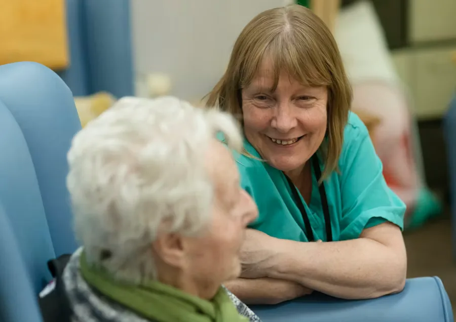 A caregiver smiling warmly with an elderly client