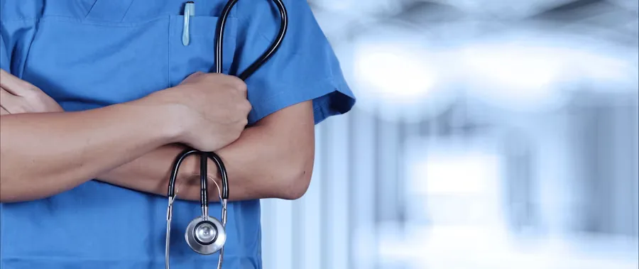 A nurse in scrubs holding a stethoscope